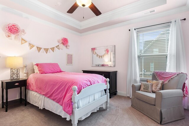 carpeted bedroom with crown molding, ceiling fan, and a tray ceiling