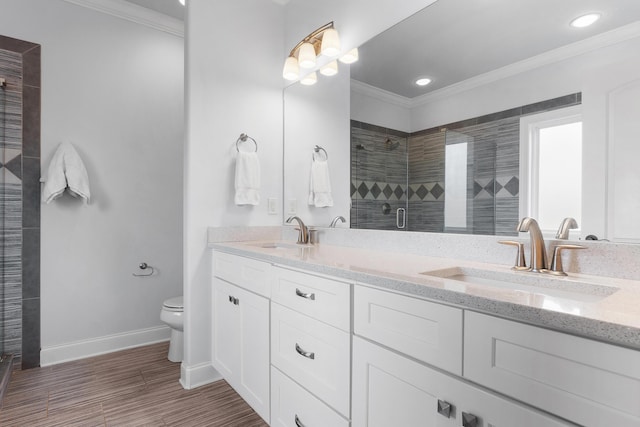 bathroom featuring toilet, an enclosed shower, ornamental molding, vanity, and hardwood / wood-style floors