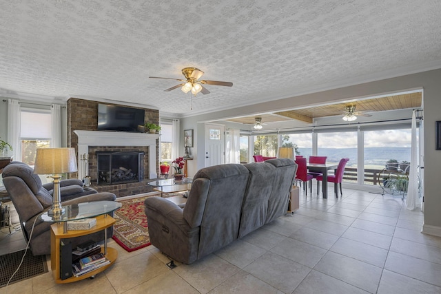 tiled living room featuring crown molding, a fireplace, and a wealth of natural light