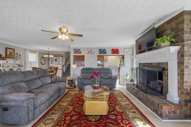 living room with crown molding, ceiling fan with notable chandelier, a brick fireplace, and a textured ceiling