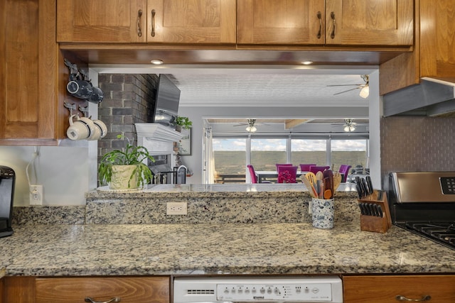 kitchen featuring light stone countertops, dishwashing machine, and stainless steel stove