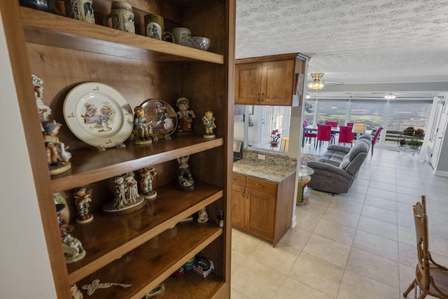 kitchen featuring light tile patterned floors, a textured ceiling, and ceiling fan