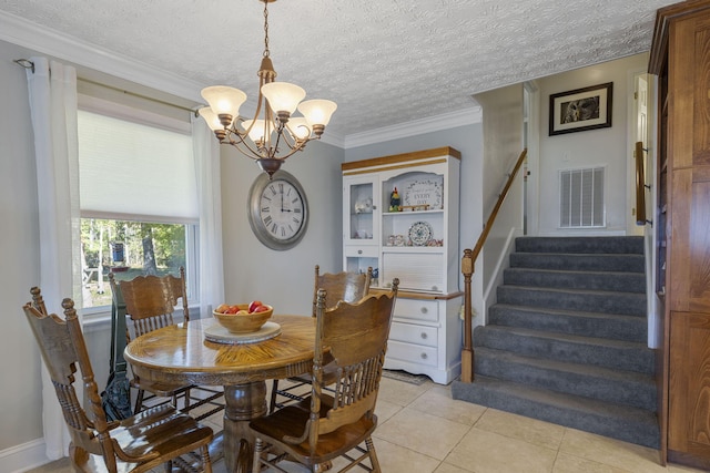 dining area with light tile patterned flooring, ornamental molding, a chandelier, and a textured ceiling