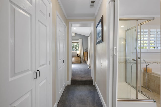 hallway featuring lofted ceiling, ornamental molding, and dark carpet