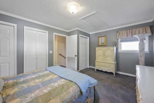 bedroom featuring crown molding, dark carpet, a textured ceiling, and multiple closets