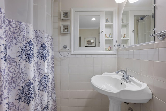 bathroom with crown molding, sink, tile walls, and a shower with shower curtain