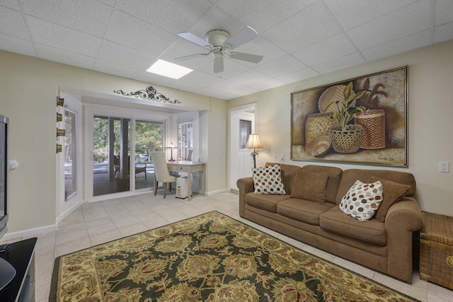 tiled living room featuring ceiling fan and a paneled ceiling