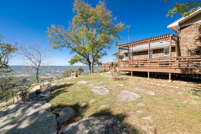 view of yard with a deck with mountain view and a pergola