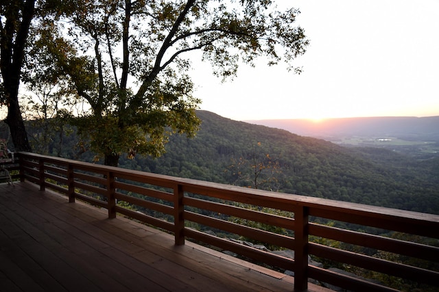 deck at dusk featuring a mountain view