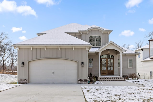 view of front of home with an attached garage, board and batten siding, concrete driveway, and french doors