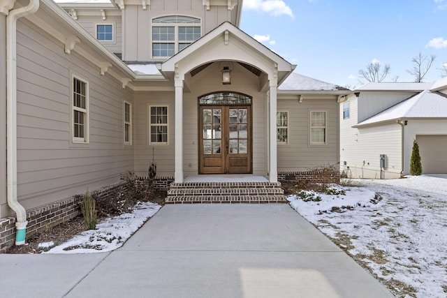 snow covered property entrance featuring french doors