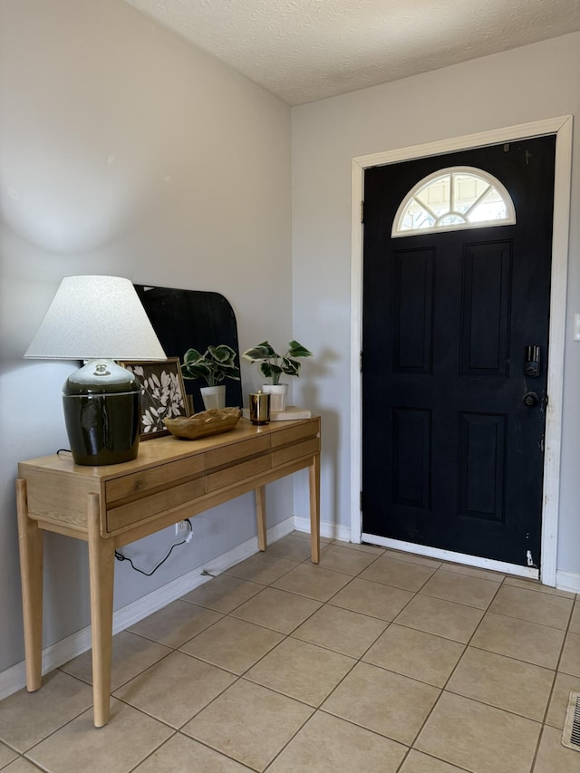 tiled entrance foyer featuring a textured ceiling