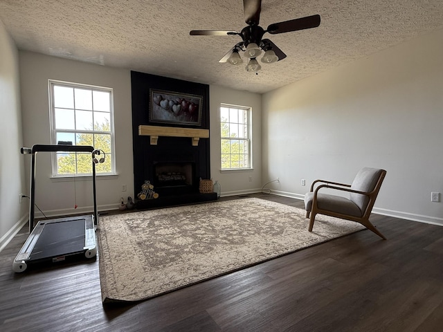 living room with a fireplace, a textured ceiling, and dark hardwood / wood-style floors