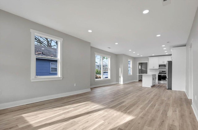 unfurnished living room featuring light wood finished floors, baseboards, and recessed lighting