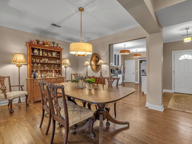 dining room featuring crown molding and wood-type flooring