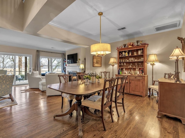 dining space featuring crown molding and wood-type flooring