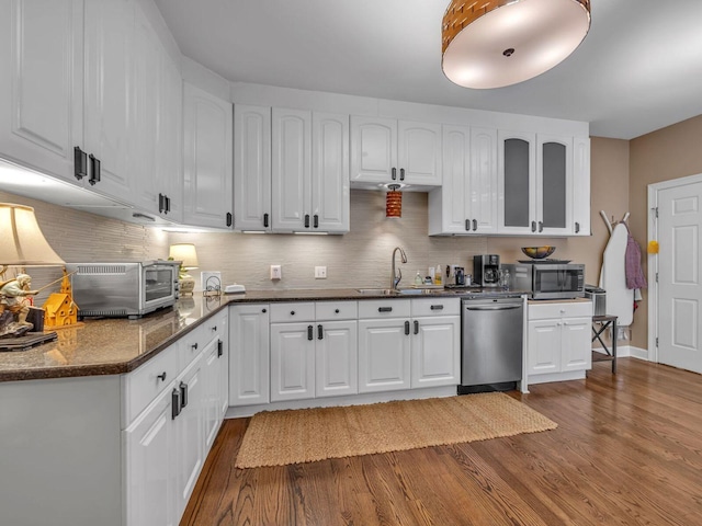 kitchen with white cabinetry, sink, dark stone counters, and appliances with stainless steel finishes