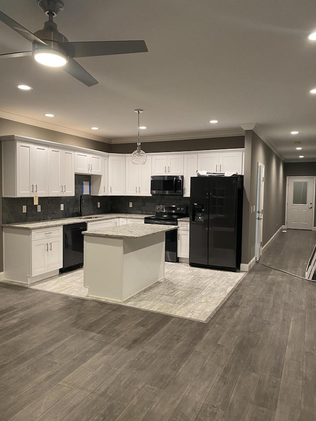 kitchen featuring sink, white cabinetry, hanging light fixtures, a center island, and black appliances