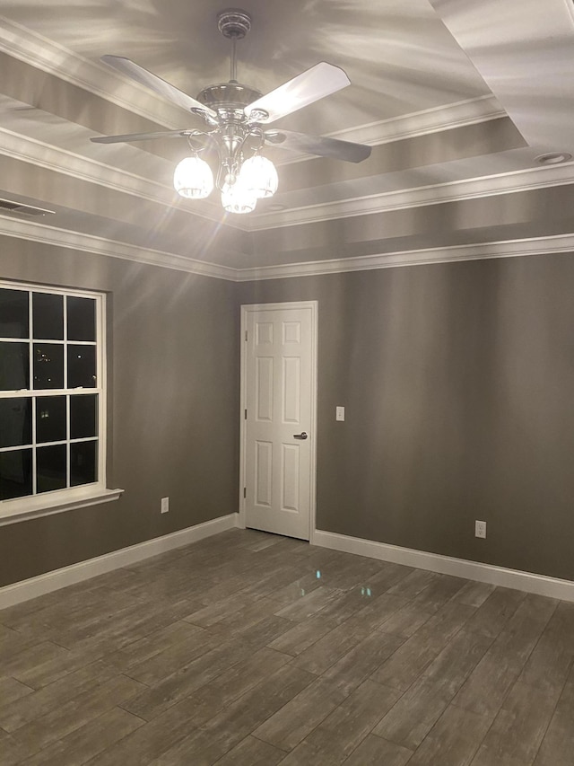 spare room featuring ceiling fan, ornamental molding, dark hardwood / wood-style floors, and a tray ceiling