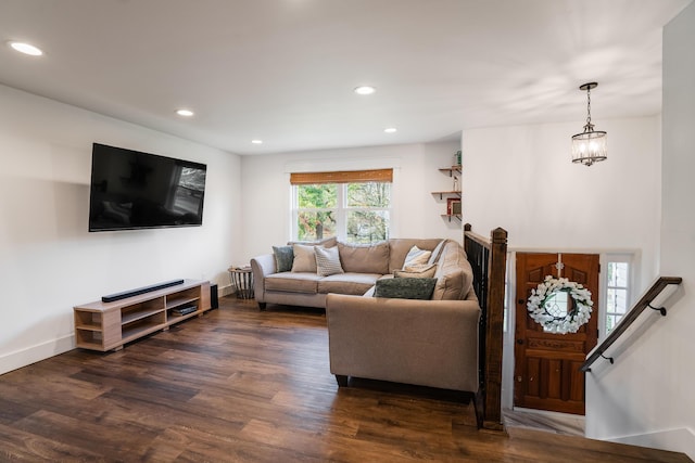 living room with dark wood-type flooring and a chandelier