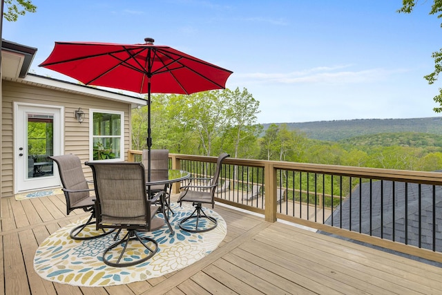 wooden deck featuring a wooded view and outdoor dining space