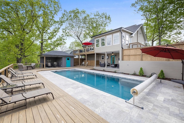 pool featuring an outbuilding, fence, a storage structure, and a patio