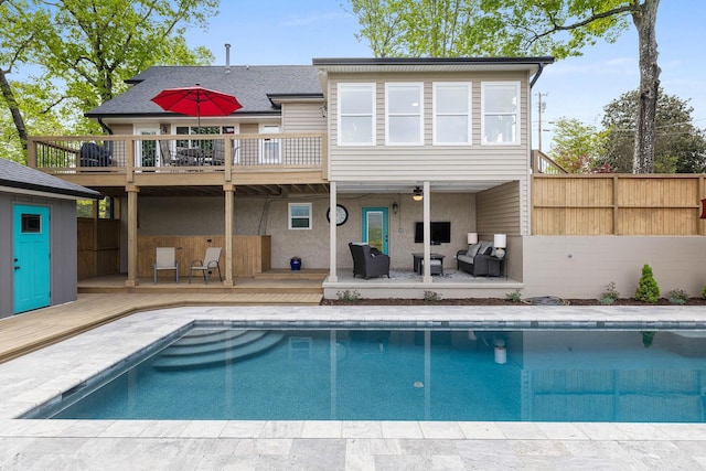 back of property with stucco siding, a shingled roof, fence, an outdoor pool, and a wooden deck