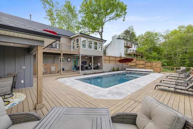 view of swimming pool with a fenced in pool and a wooden deck