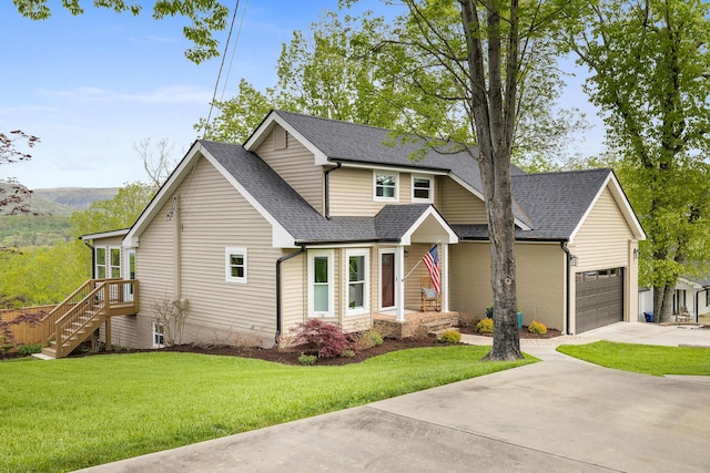 view of front of home featuring a front yard, concrete driveway, and roof with shingles