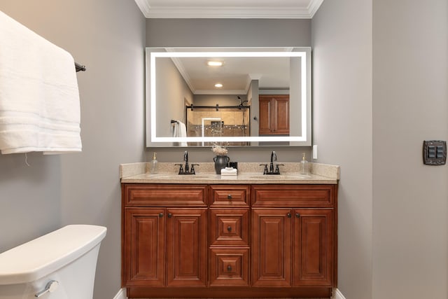 bathroom featuring toilet, crown molding, double vanity, and a sink