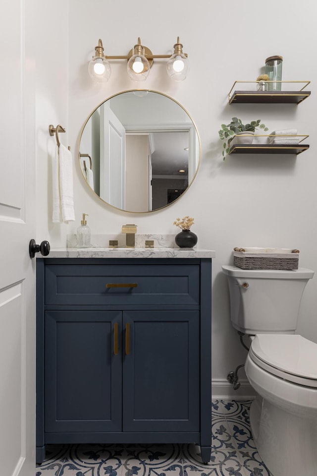 half bath featuring toilet, baseboards, and vanity