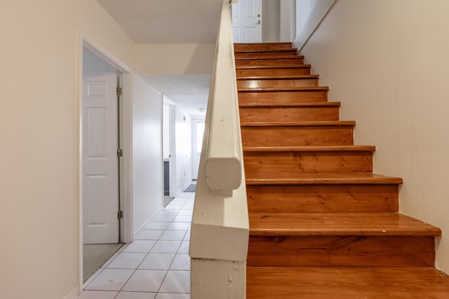 stairs featuring tile patterned floors