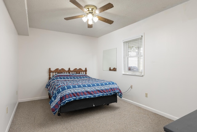 carpeted bedroom featuring ceiling fan and a textured ceiling