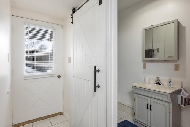 bathroom with a textured ceiling, tile patterned flooring, and vanity