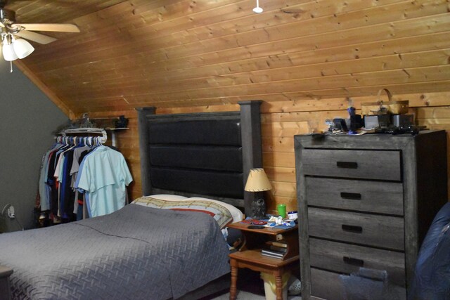 bedroom featuring vaulted ceiling, wooden ceiling, and wooden walls