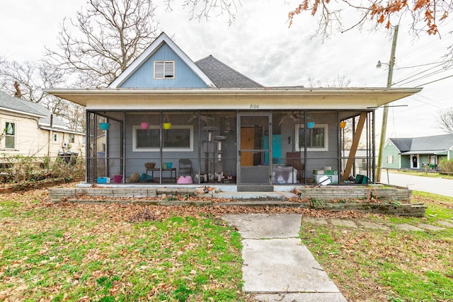 view of front of home with a front lawn and a sunroom