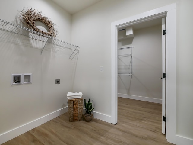 washroom featuring electric dryer hookup, hookup for a washing machine, and light hardwood / wood-style flooring