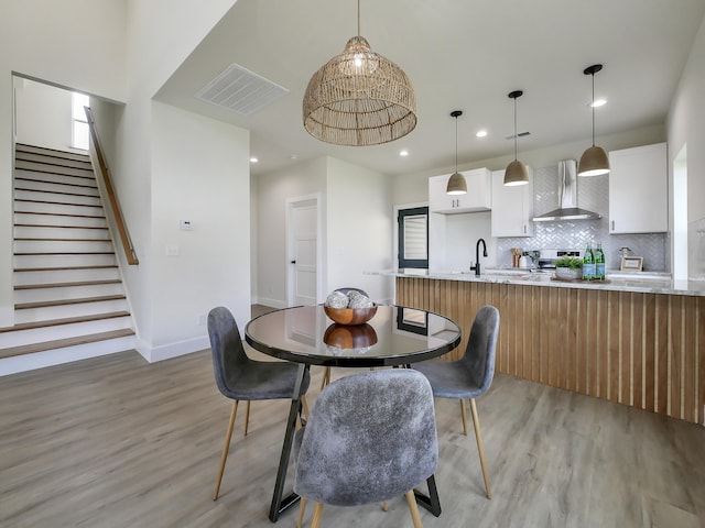 dining room featuring sink and light hardwood / wood-style floors