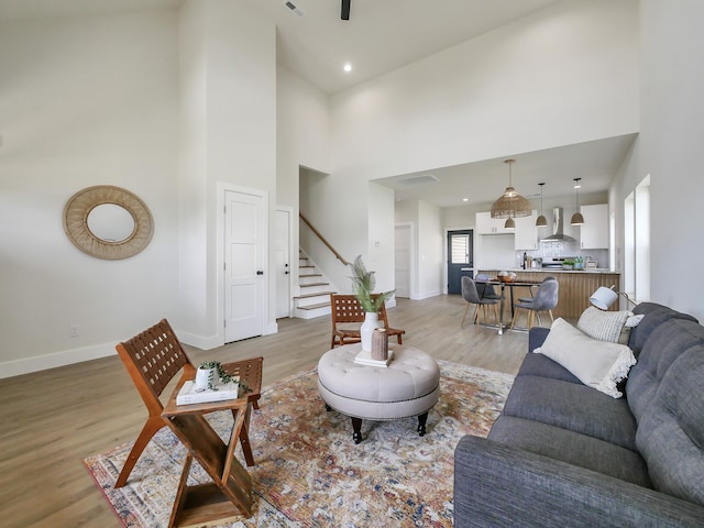 living room with a high ceiling and light wood-type flooring