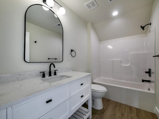 full bathroom with hardwood / wood-style flooring, toilet, vanity, and  shower combination