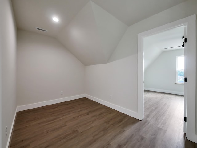 bonus room with dark hardwood / wood-style floors and vaulted ceiling