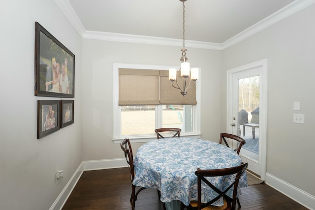 dining room with dark wood-type flooring, crown molding, and an inviting chandelier