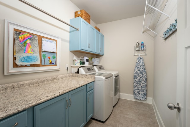 laundry room with cabinets, washer and dryer, and light tile patterned floors