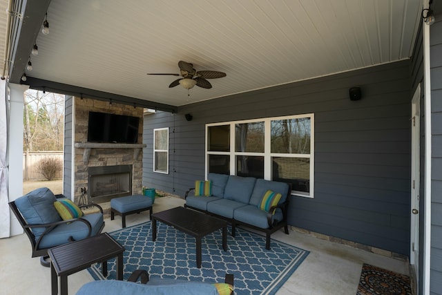 view of patio with an outdoor living space with a fireplace and ceiling fan