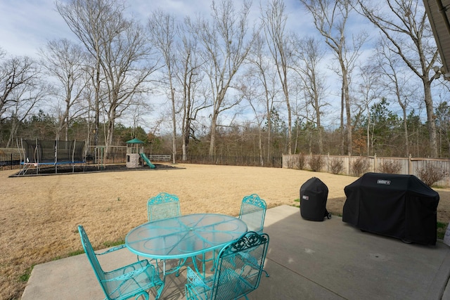 view of patio with a grill, a playground, and a trampoline