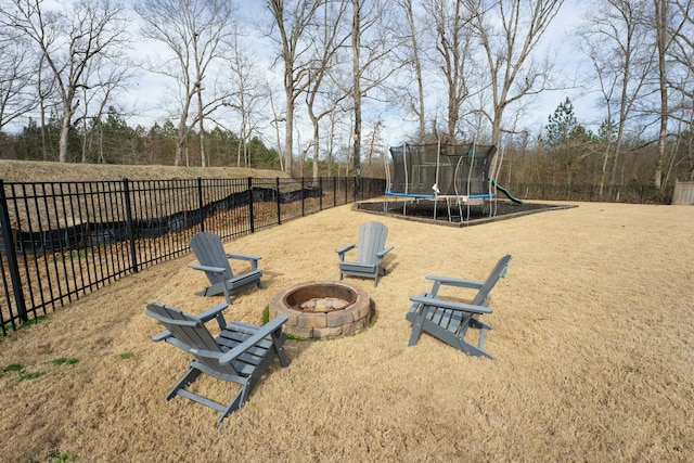 view of jungle gym featuring a trampoline and a fire pit