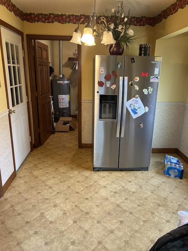kitchen featuring gas water heater, pendant lighting, and stainless steel fridge