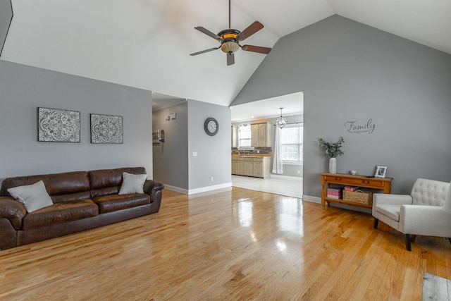 190 Sycamore Dr, Chickamauga, GA 30707 - living room featuring a ceiling fan, high vaulted ceiling, baseboards, a chandelier, and light wood-type flooring