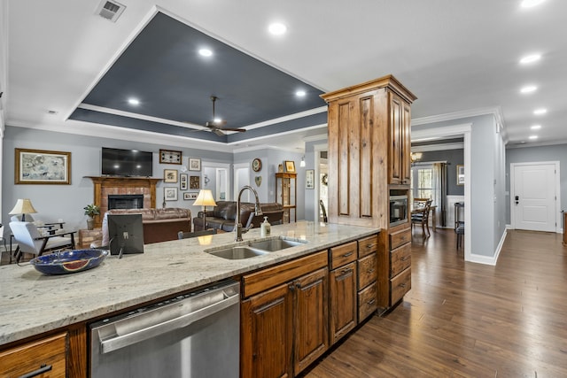 kitchen featuring a fireplace, a sink, visible vents, dishwasher, and a raised ceiling