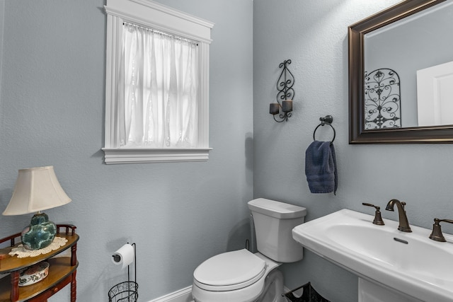 half bath featuring a sink and toilet